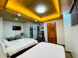 a hotel room with two beds and a television at Nica's Palace Baguio in Baguio