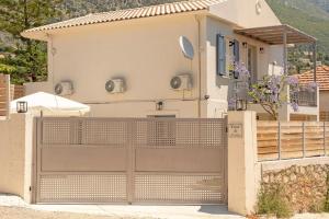 a house with a wooden gate and a fence at Casa di Cona Lourdas in Lourdata