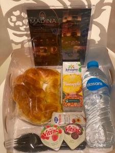 a lunch box with a croissant and a bottle of water at Madina Boutique Hotel in Luxor