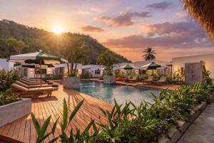 an image of a resort swimming pool with the sun setting at Alcazaba Resort Lombok in Kuta Lombok