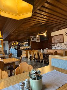 a restaurant with wooden ceilings and tables and chairs at Berggasthof Hinterreit in Maria Alm am Steinernen Meer