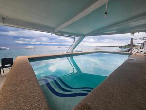 a swimming pool with a view of the ocean at SARDINEBAY Dive Resort in Moalboal