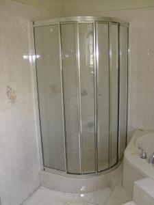 a shower with glass doors in a bathroom at Griffiths Guest House in White Hill +28 photos
