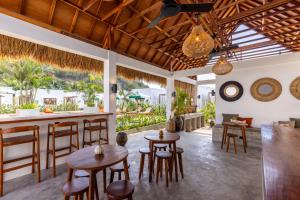 a bar in a villa with wooden stools and tables at Alcazaba Resort Lombok in Kuta Lombok