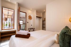 a bedroom with a large white bed and a window at Alcazaba Resort Lombok in Kuta Lombok +16 photos