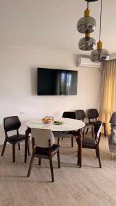 a dining room with a table and chairs and a tv at Modinakhe in Kobuleti