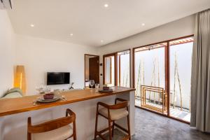 a kitchen with a bar with chairs and a living room at Alcazaba Resort Lombok in Kuta Lombok