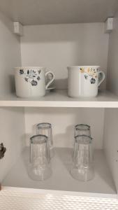 a shelf with two cups and two glasses on it at Apartmán pro 2 osoby, Bukovany B3 in Sokolov