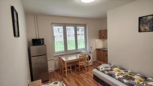 a living room with a couch and a kitchen with a table at Apartmán pro 2 osoby, Bukovany B3 in Sokolov