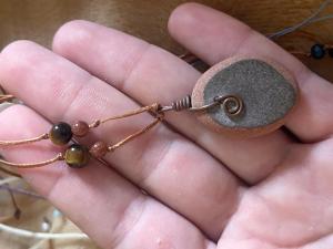 a hand holding a stone and a piece of copper wire at Clinica apartments in Bologna