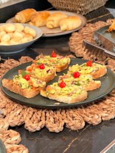 a table with plates of food on a table with bread at Kairos Beach Hotel in Camocim