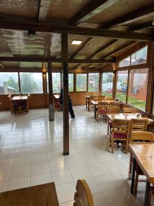 a dining room with tables and chairs and windows at Ayder Serender Otel in Çamlıhemşin