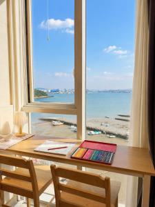 a desk with a window with a view of the beach at Mood Ocean 인천 영종도 in Chagyak-to