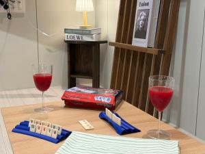 a table with two glasses of red wine and dominoes at Mood Ocean 인천 영종도 in Chagyak-to