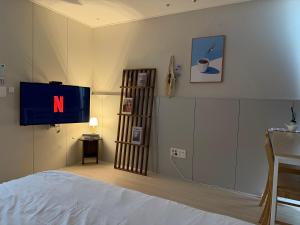 a bedroom with a tv with the letter n on it at Mood Ocean 인천 영종도 in Chagyak-to