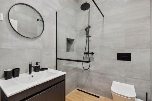 a bathroom with a sink and a shower with a mirror at Modern Studio Old Town by MN Property in Kotor +1 photo