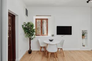 a white dining room with a table and chairs at Modern Studio Old Town by MN Property in Kotor