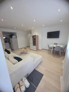 ein Wohnzimmer mit einem großen Sofa und einem Tisch in der Unterkunft Vertu'Ose avec jacuzzi in Morbier
