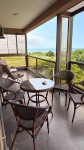 a balcony with chairs and a table and a view of the ocean at Modinakhe in Kobuleti