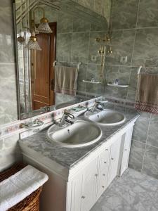 a bathroom with two sinks and a large mirror at SERRA e MAR in Murtais