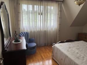 a bedroom with a bed and a chair and a table at SERRA e MAR in Murtais +5 photos