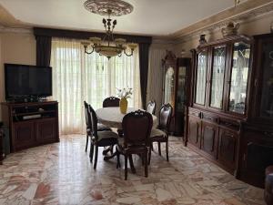 a dining room with a table and chairs and a television at SERRA e MAR in Murtais