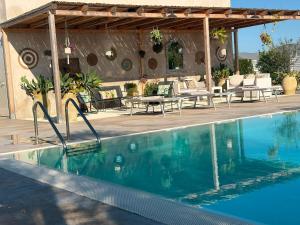 a swimming pool with a patio with a table and chairs at Agri Lemon Green in Pachino