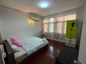 a small bedroom with a bed and a window at Casa Nicola BKK in Ban Na Song