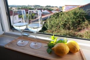 two glasses of white wine sitting on a window sill at Casa Ferreira in Olaia