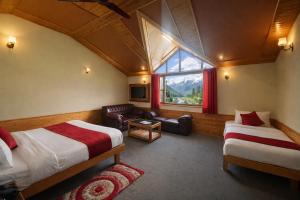 a hotel room with two beds and a window at Hotel Hollywood Vibes #riverview #premium rooms #prime location #most awarded #parking #top rated #open terrace #lawn #best selling hotel in manali in Manāli