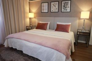 a bedroom with a large white bed with two lamps at Casa Ferreira in Olaia