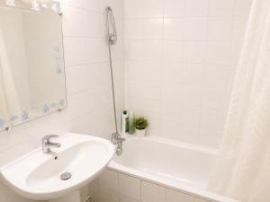 a white bathroom with a sink and a tub at Prestige appart in Chalon-sur-Saône