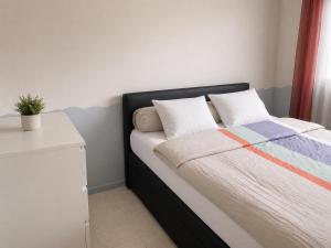 a bed with two pillows and a table in a room at Prestige appart in Chalon-sur-Saône