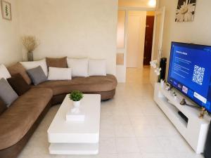 a living room with a couch and a flat screen tv at Prestige appart in Chalon-sur-Saône