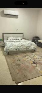 a bedroom with a bed and a rug on the floor at فيلا in Salalah