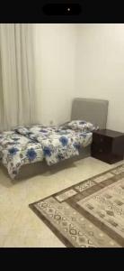 a bedroom with a bed and a rug on the floor at فيلا in Salalah