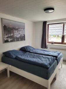 a bedroom with a bed with blue sheets and a window at Marktstube in Marsberg