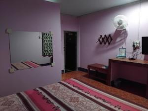 a room with a bed and a desk and a mirror at Saran Resort room 5 in Ban Khok Wat