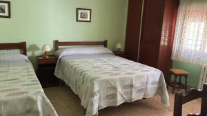 een slaapkamer met twee bedden, twee tafels en een raam bij Pinarillos in Sarvisé