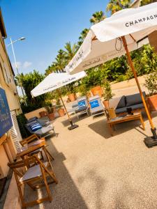 a group of chairs and umbrellas on a patio at Unique Hôtel Résidence & Spa in Saint-Raphaël