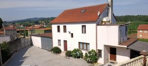 a white house with a red roof at Casa O segredo, Costa da Morte con piscina in Coristanco