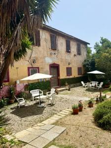 an outdoor patio with chairs and umbrellas in front of a building at Casale di Torvaianica in Campo Iemini