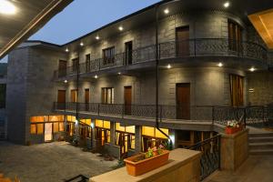un grande edificio con due balconi e un cortile di Rubin Hotel a Goris