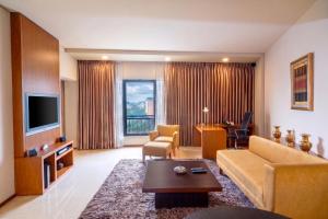 a living room with a couch and a tv at Radisson Blu Dhaka Water Garden in Dhaka