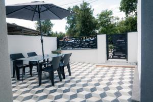 a patio with a table and chairs and an umbrella at Nora Apartments in Jagodina