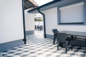 a dining room with a table and chairs on a checkered floor at Nora Apartments in Jagodina