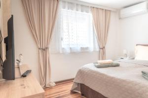 a bedroom with a bed and a large window at Nora Apartments in Jagodina