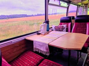 a table in the back of a train with a window at Retro Saunabuss Valgamaal in Sooblase
