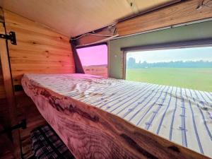 a bed in a room with a large window at Retro Saunabuss Valgamaal in Sooblase