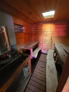 a wooden cabin with benches and a stove in it at Retro Saunabuss Valgamaal in Sooblase